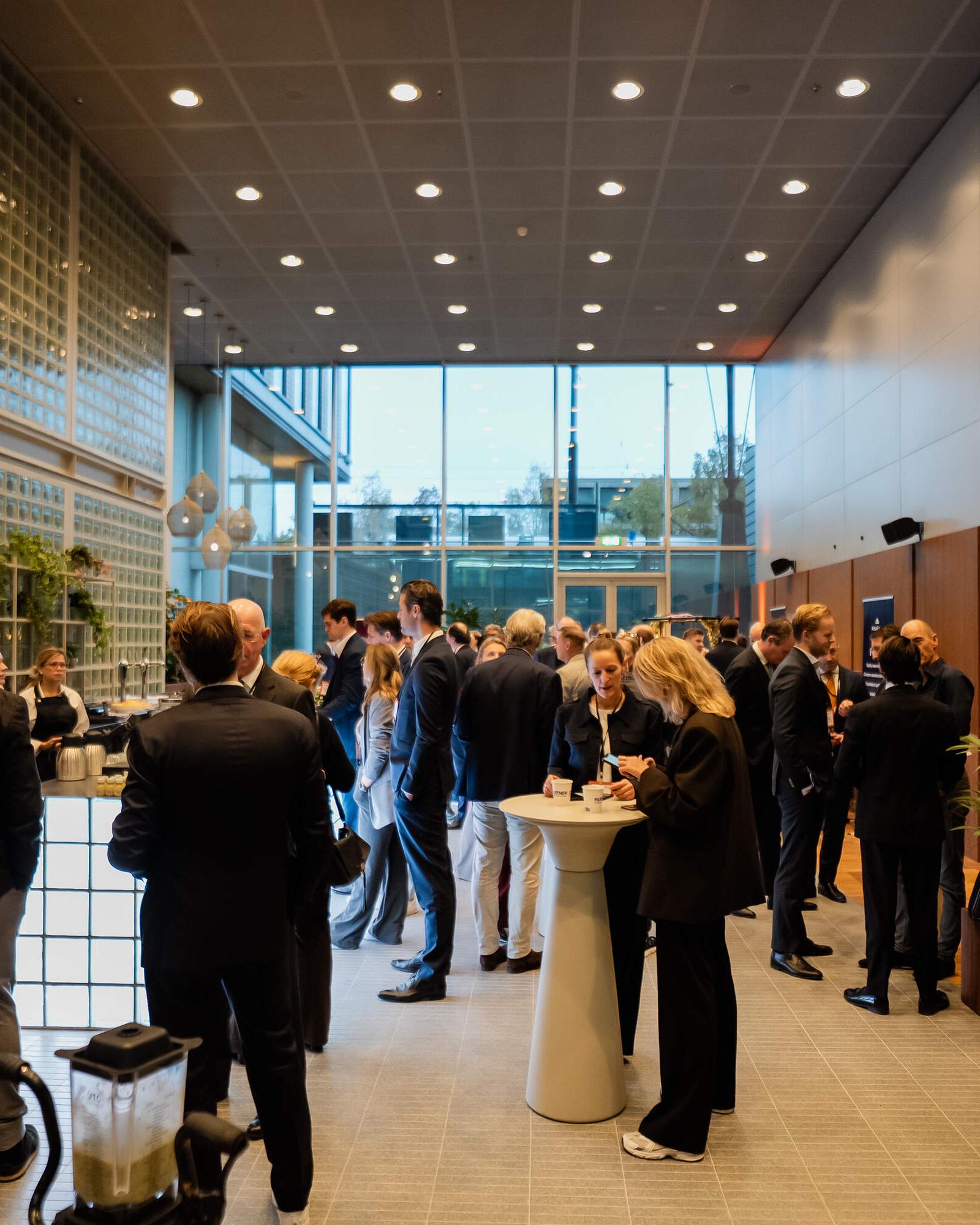 Gasten in de Foyer van WTC Amsterdam tijdens een zakelijk evenement