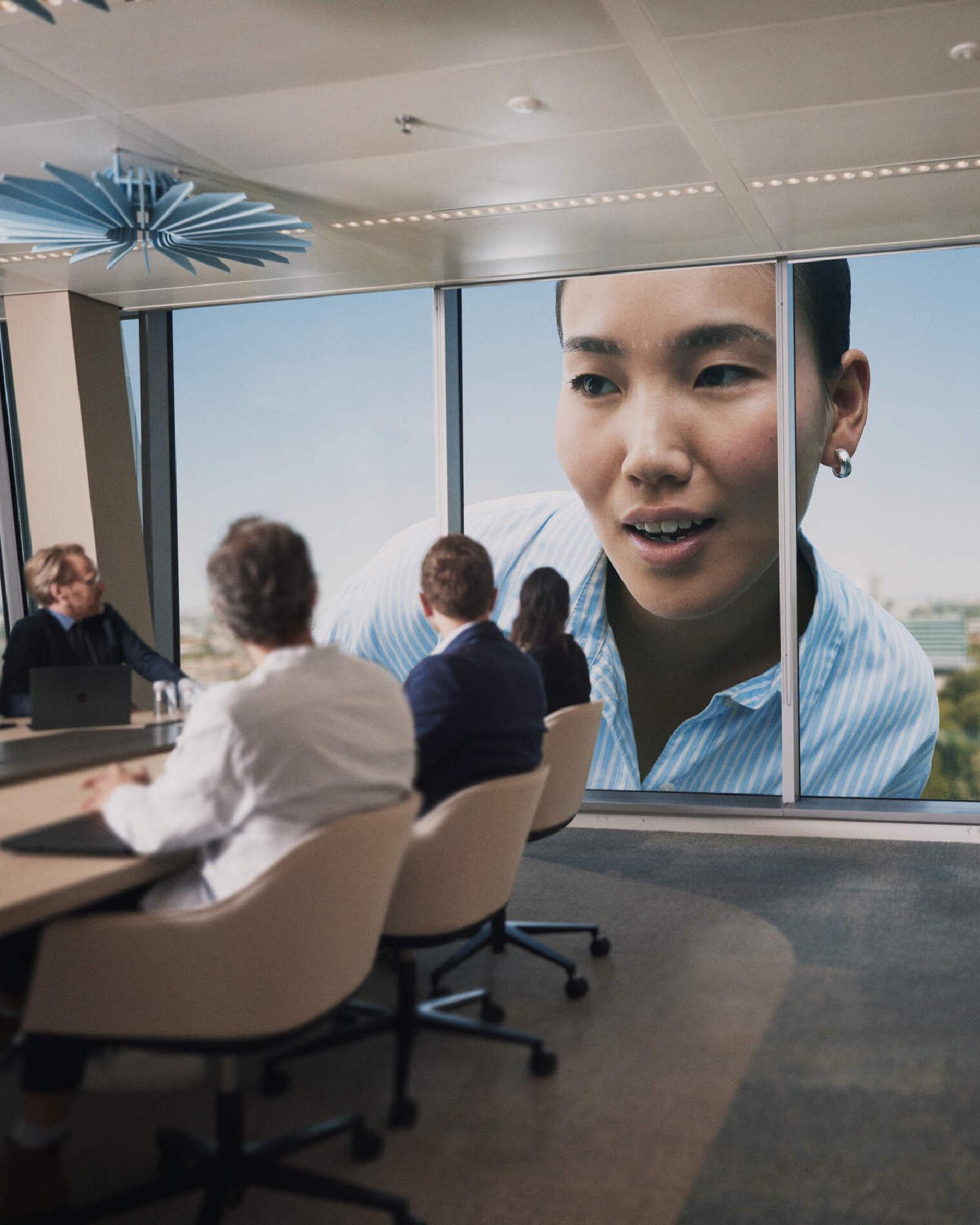 Woman looking in through the window of a meeting room at WTC Amsterdam