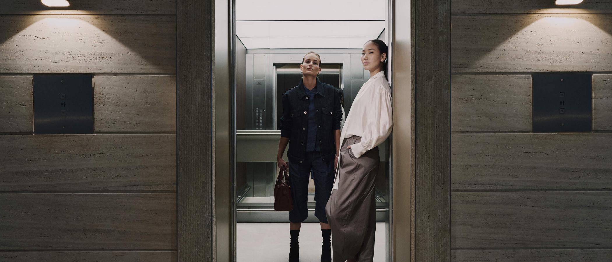 Two women stepping out of an elevator at WTC Amsterdam